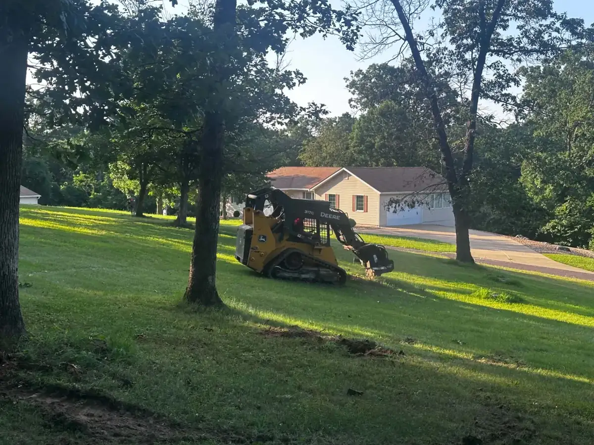 Stump grinding with a John Deere 317G in a front yard