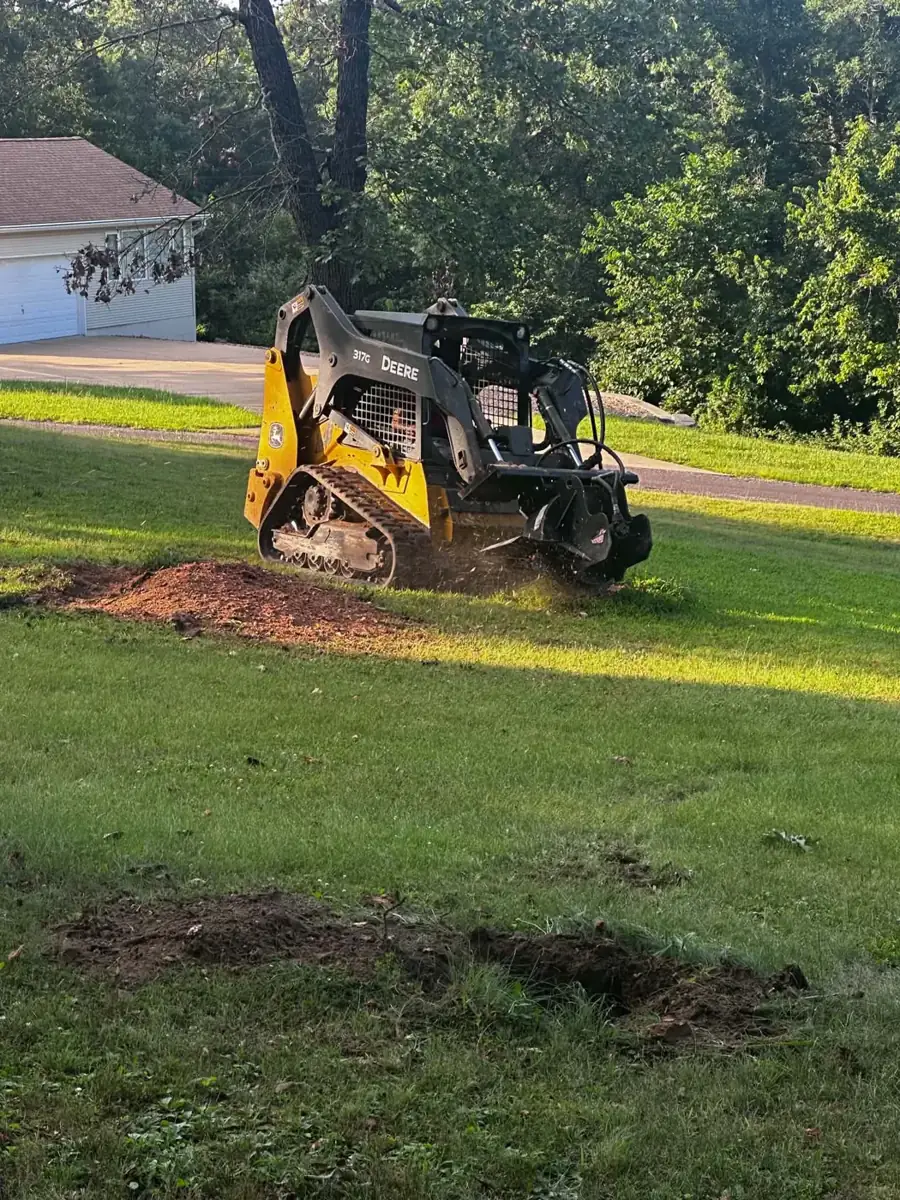 Stump grinder throwing wood chips in a yard